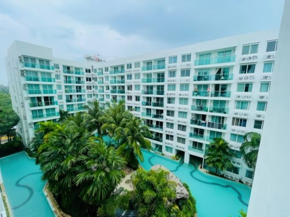 Modern furnished living room with balcony overlooking lagoon-style pool – Amazon Residence Jomtien