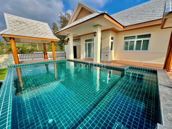 Private swimming pool with sun loungers in luxurious Jomtien villa.