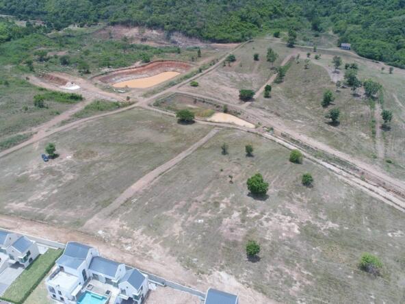 Aerial view of expansive land for sale in Khao Yai, showcasing green fields and surrounding forest.
