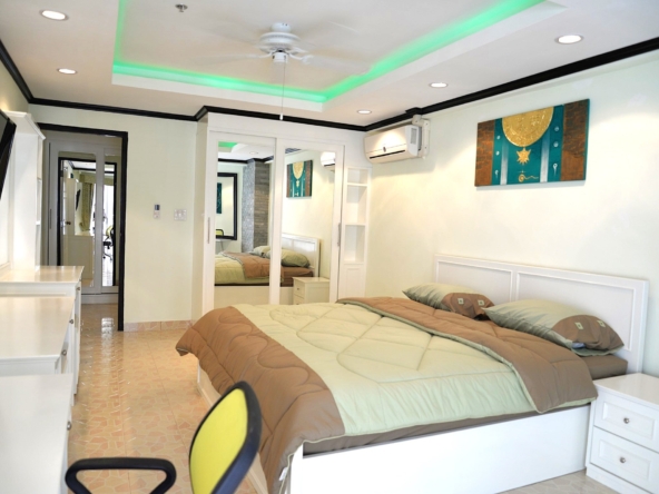 Spacious bedroom with large windows and modern decor at Jomtien Beach Condominium.