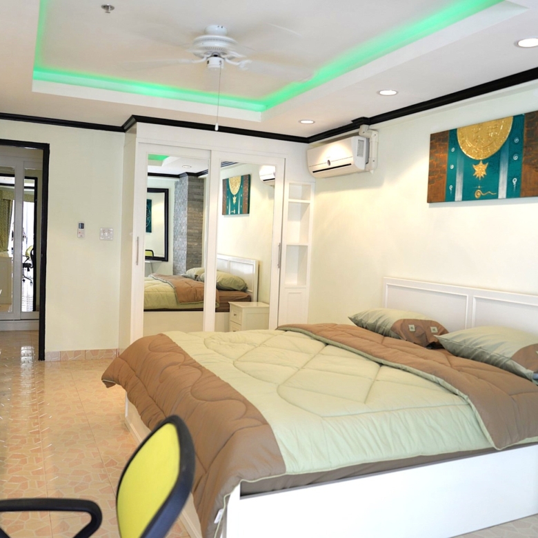 Spacious bedroom with large windows and modern decor at Jomtien Beach Condominium.